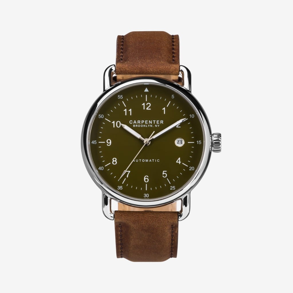 Green-dial wristwatch with brown leather strap on white background.