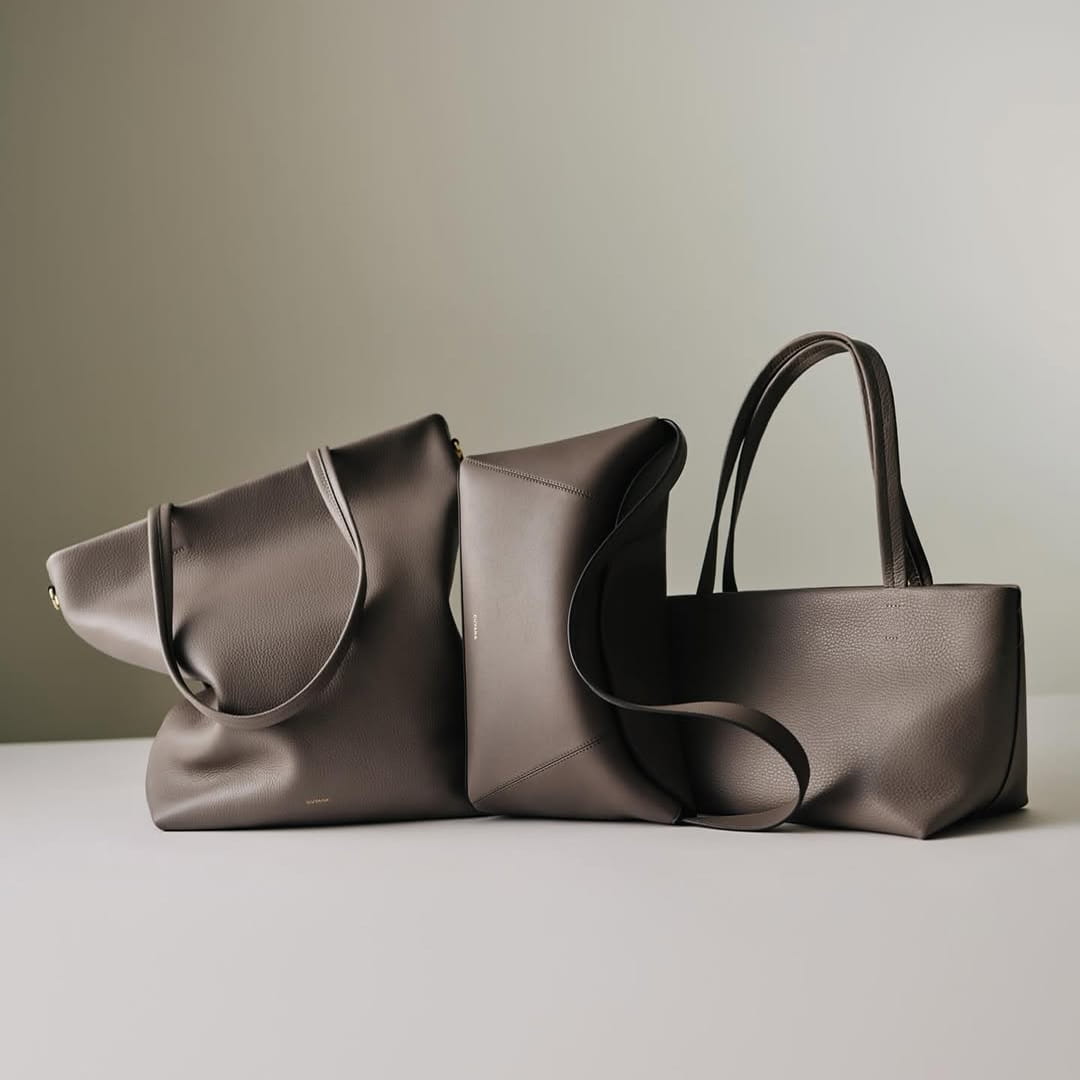 Minimalist black leather tote bag set on a neutral studio background